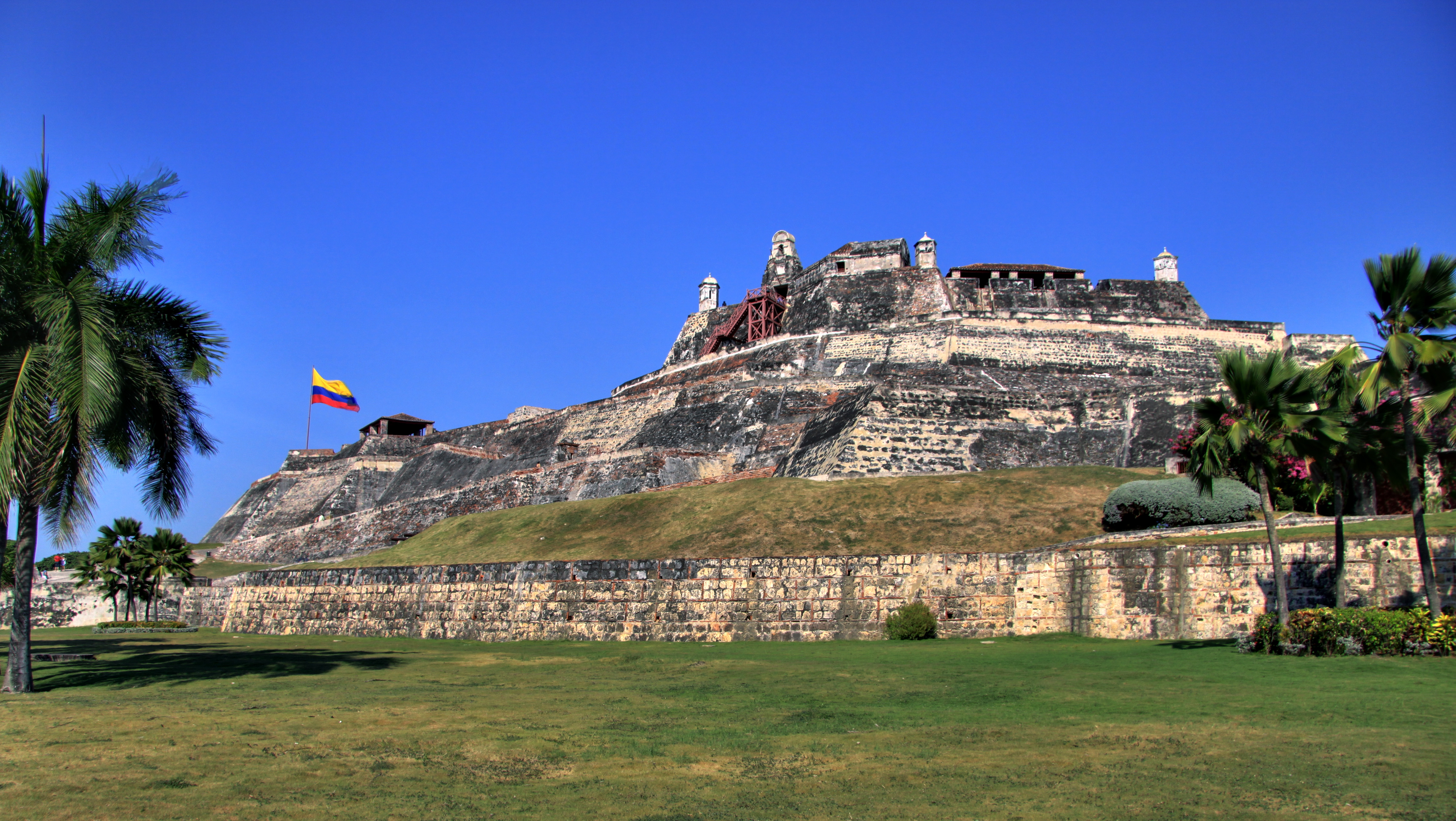 Vista imponente do Castelo de San Felipe de Barajas em Cartagena, fortaleza histórica com a bandeira da Colômbia hasteada.