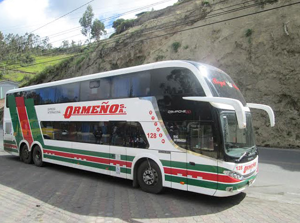 Ônibus de dois andares da empresa Expreso Internacional Ormeño, conhecida por longas rotas terrestres na América do Sul, estacionado na estrada durante uma viagem.