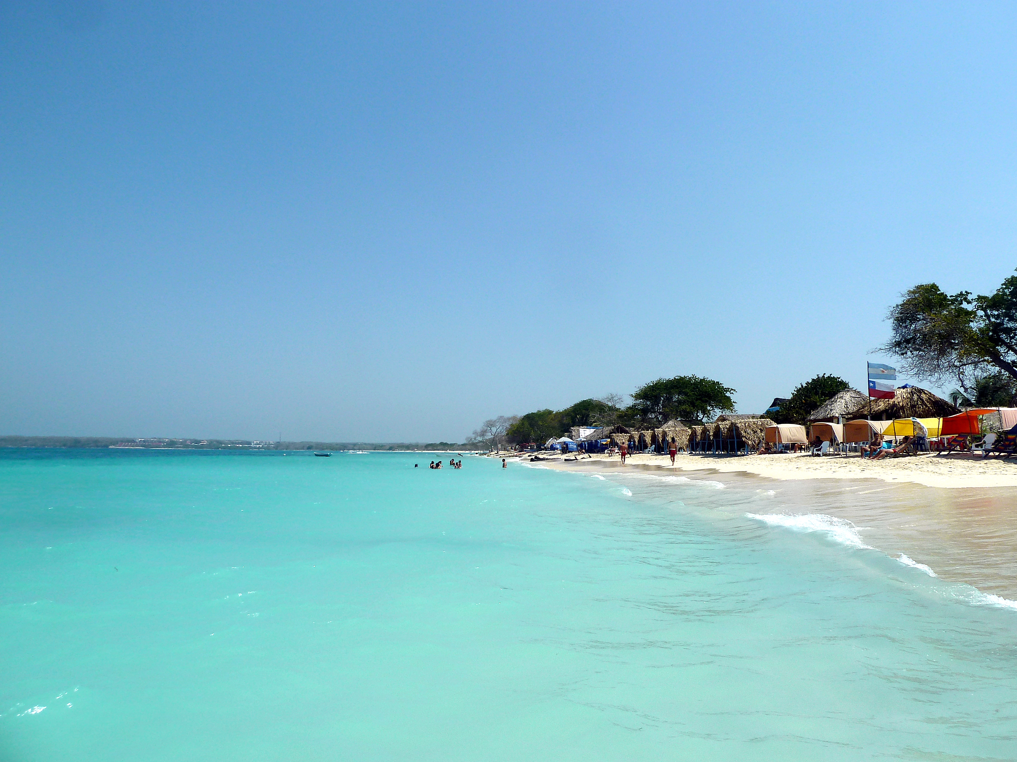 Águas azul-turquesa e areia branca da Playa Blanca na Isla Barú, paradisíaca praia caribenha próxima a Cartagena das Índias.
