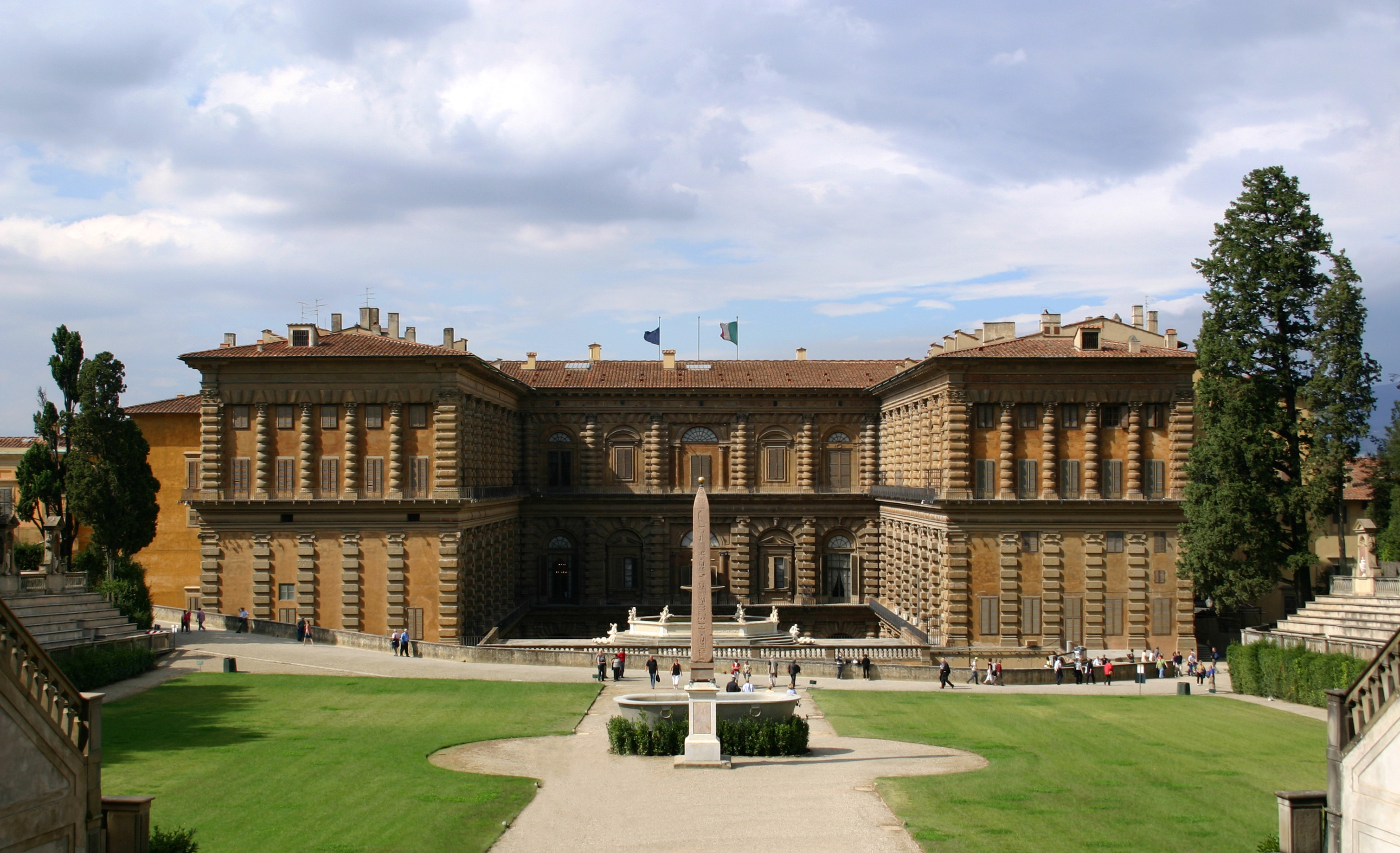 Fachada imponente do Palazzo Pitti vista dos Jardins de Boboli em Florença, mostrando a arquitetura renascentista e o anfiteatro.