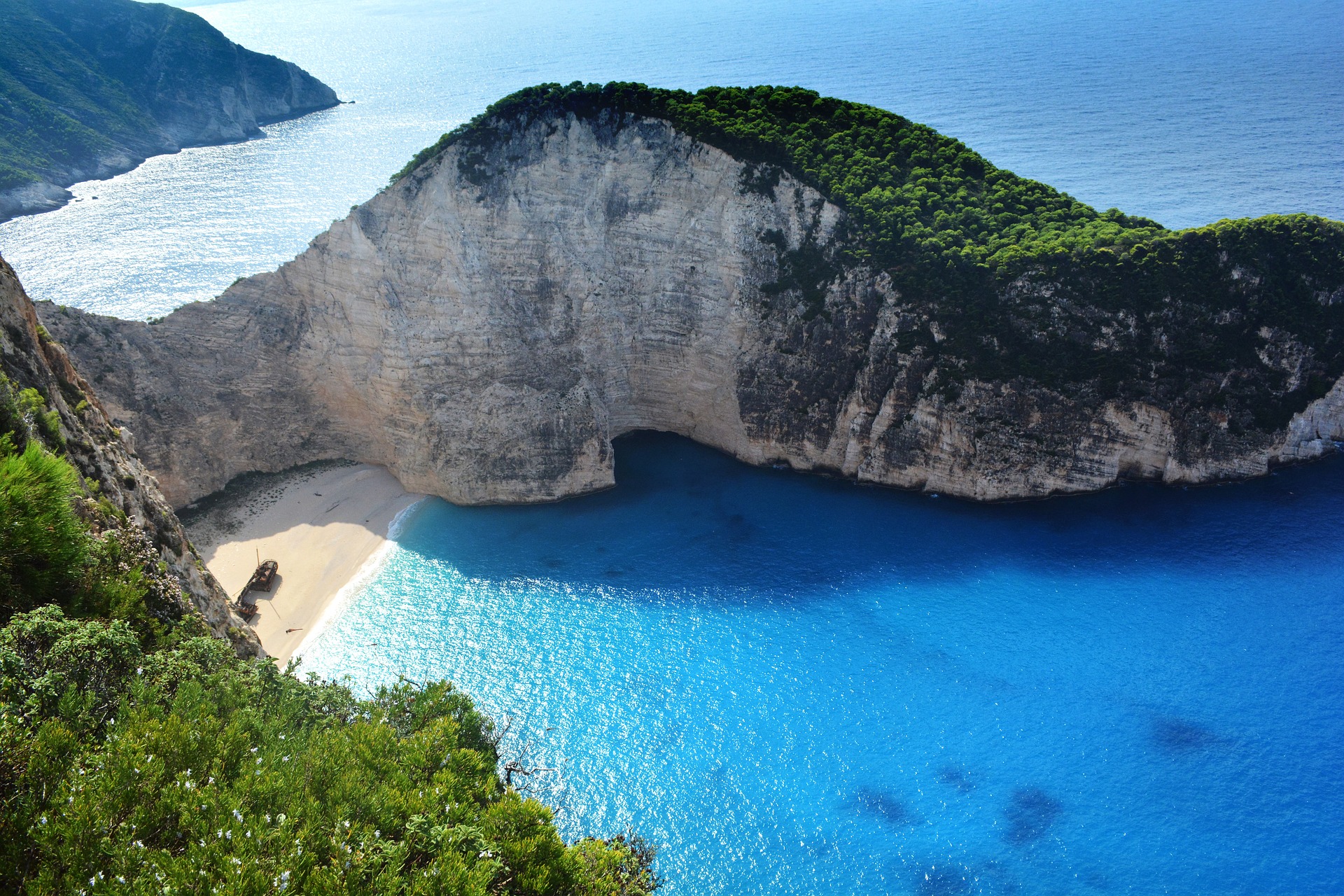 Vista aérea da Praia de Navagio na Grécia, um destino paradisíaco popular para inspiração e planejamento de viagens internacionais de verão.