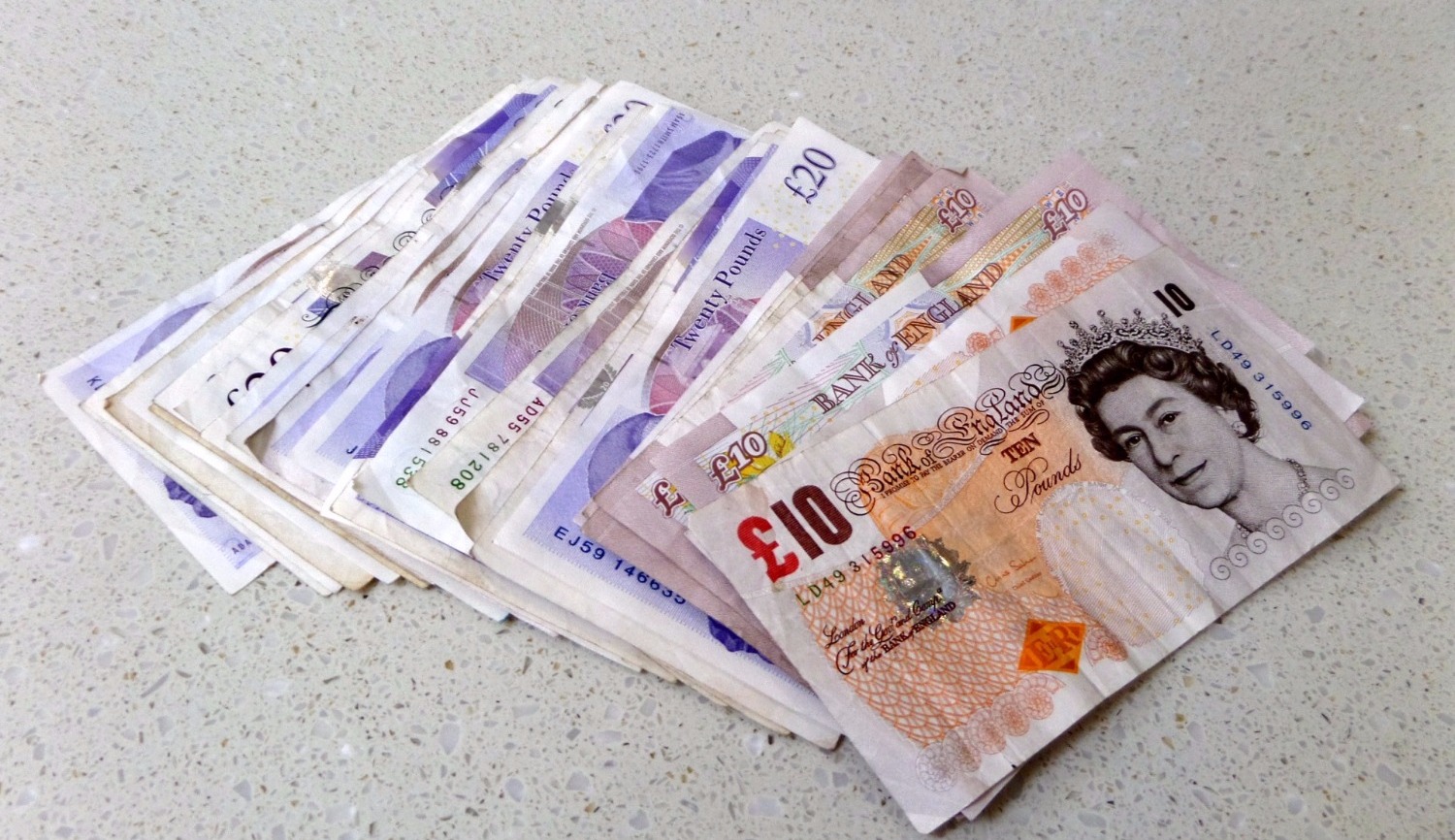 Notas de Libra Esterlina espalhadas sobre superfície