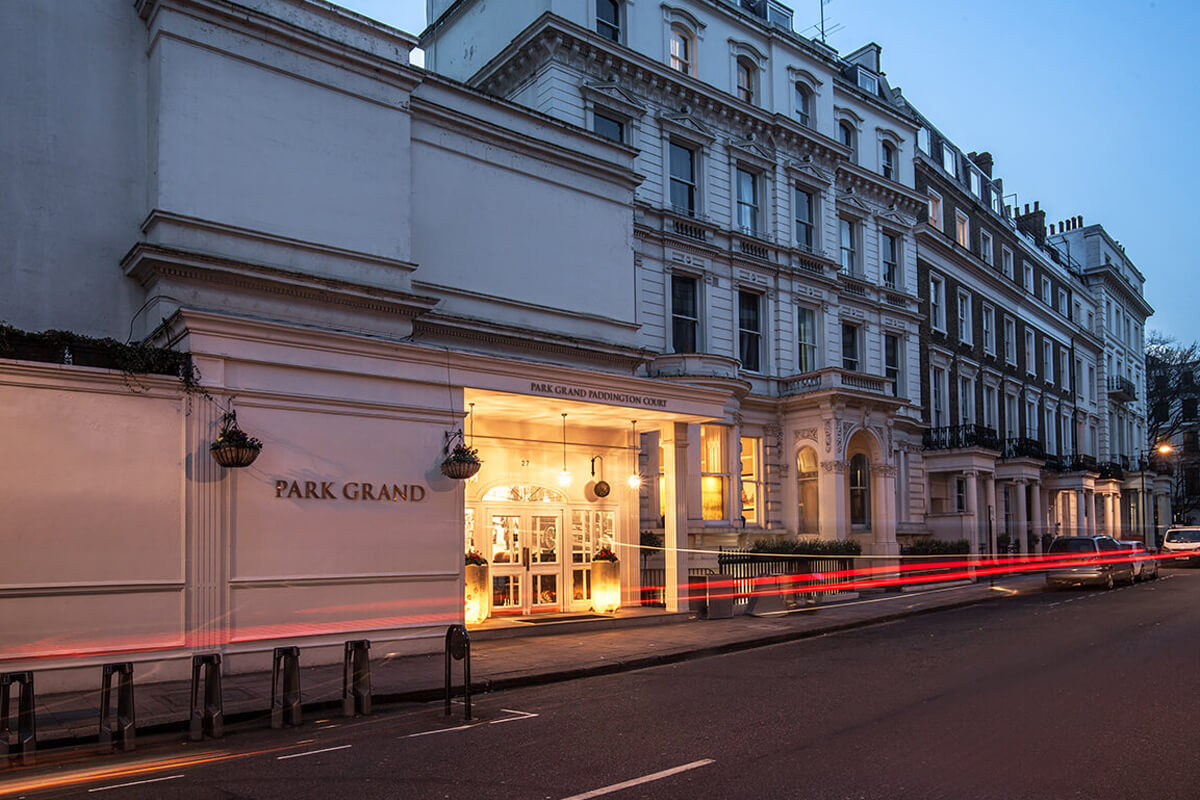 Fachada elegante e iluminada do Hotel Park Grand Paddington Court